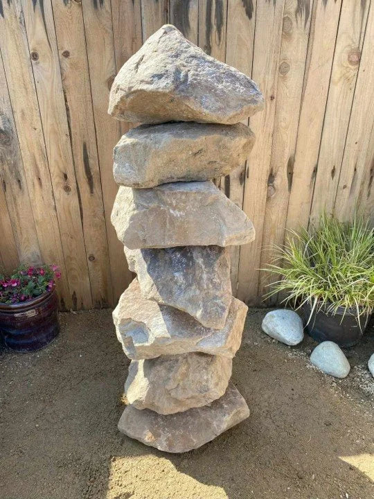 Large golden granite water feature, 1000 mm, stacked in a backyard garden.