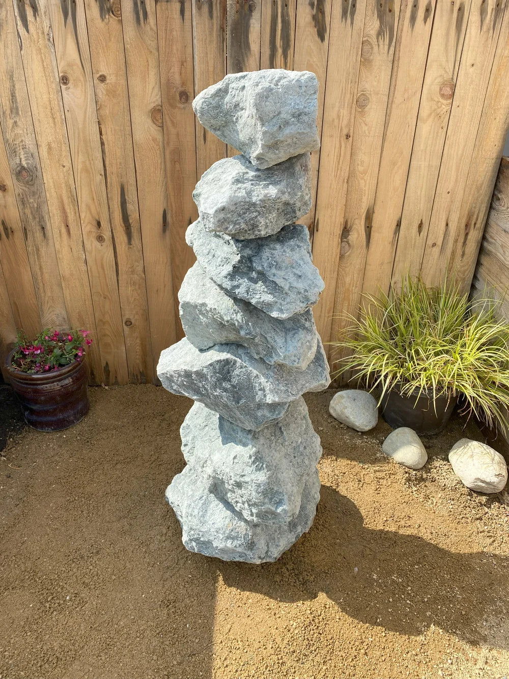 Large green granite pyramid stacked stones, 1000mm tall, with rugged texture, sitting on brown pebbles.