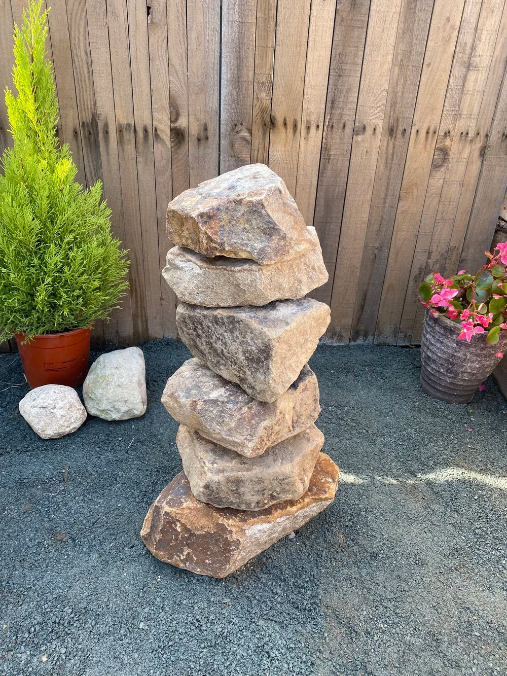 Golden granite pyramid stacked stones (600mm) with rough texture, placed in an outdoor setting.