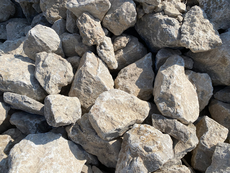 Grey limestone decorative pond stones with a rough, textured surface.