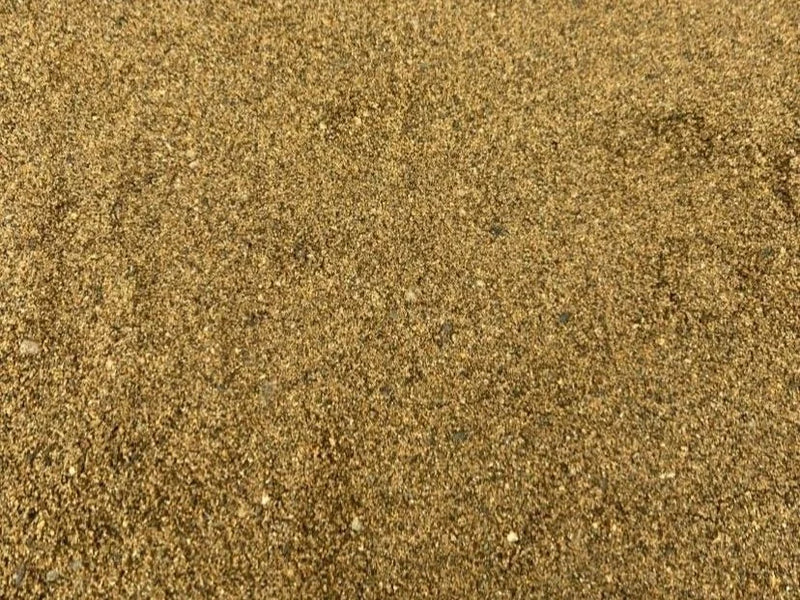 Tan building sand in bulk bag with fine, gritty texture.