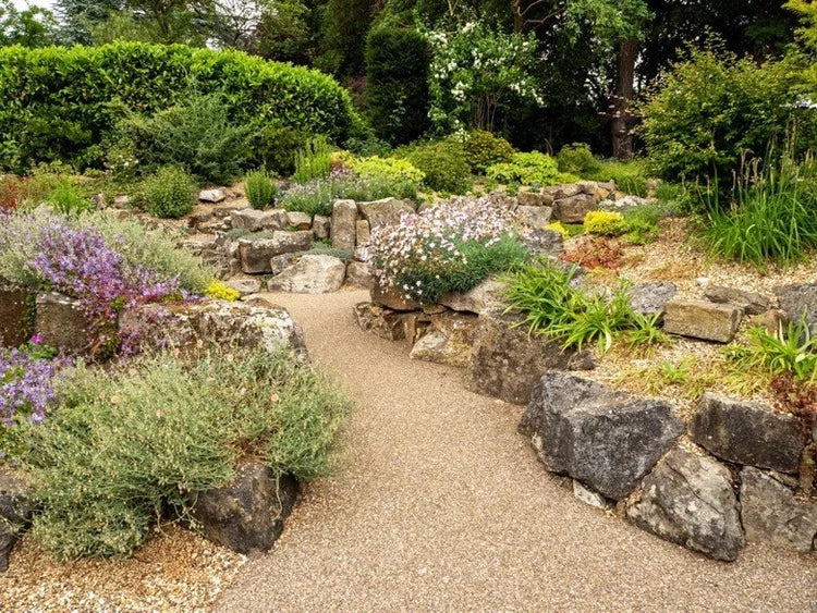 Golden granite self bind bulk bag with a fine texture, displayed among rocks and garden plants.