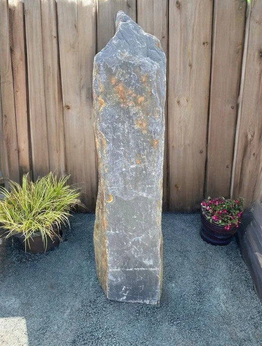 Grey slate monolith standing stone, with rough texture, featuring orange markings