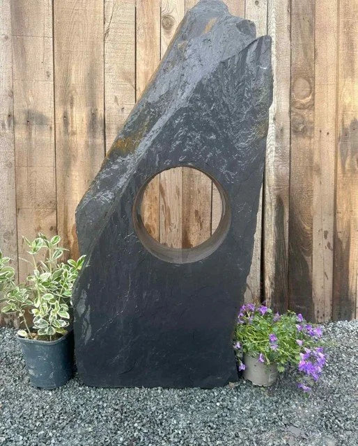 Grey slate water feature by Hollolith, with a circular cutout and natural stone texture.