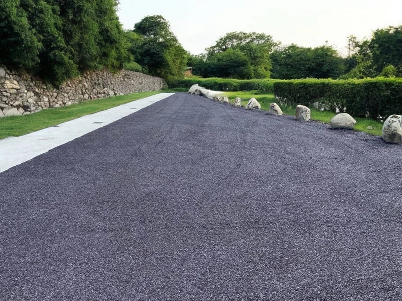 Plum slate self bind by an unknown brand, set on an outdoor driveway with green grass and rock accents.