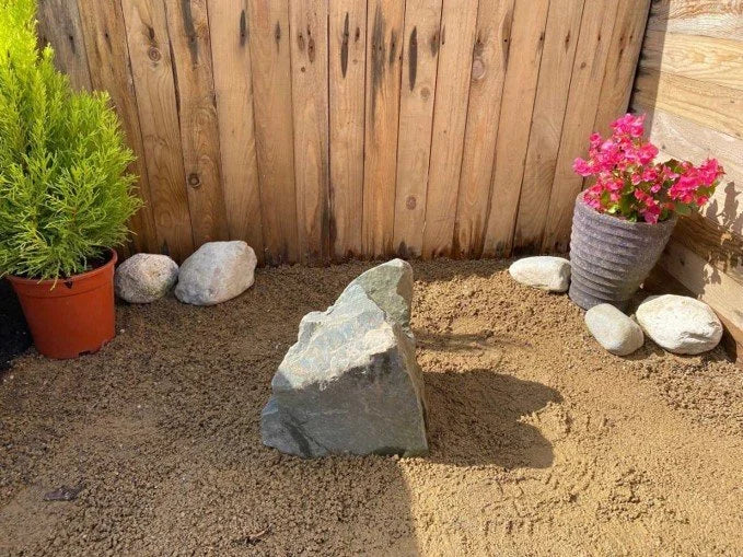 Natural rock water feature by RWF04, displaying a drilled hole and a rugged, textured surface.