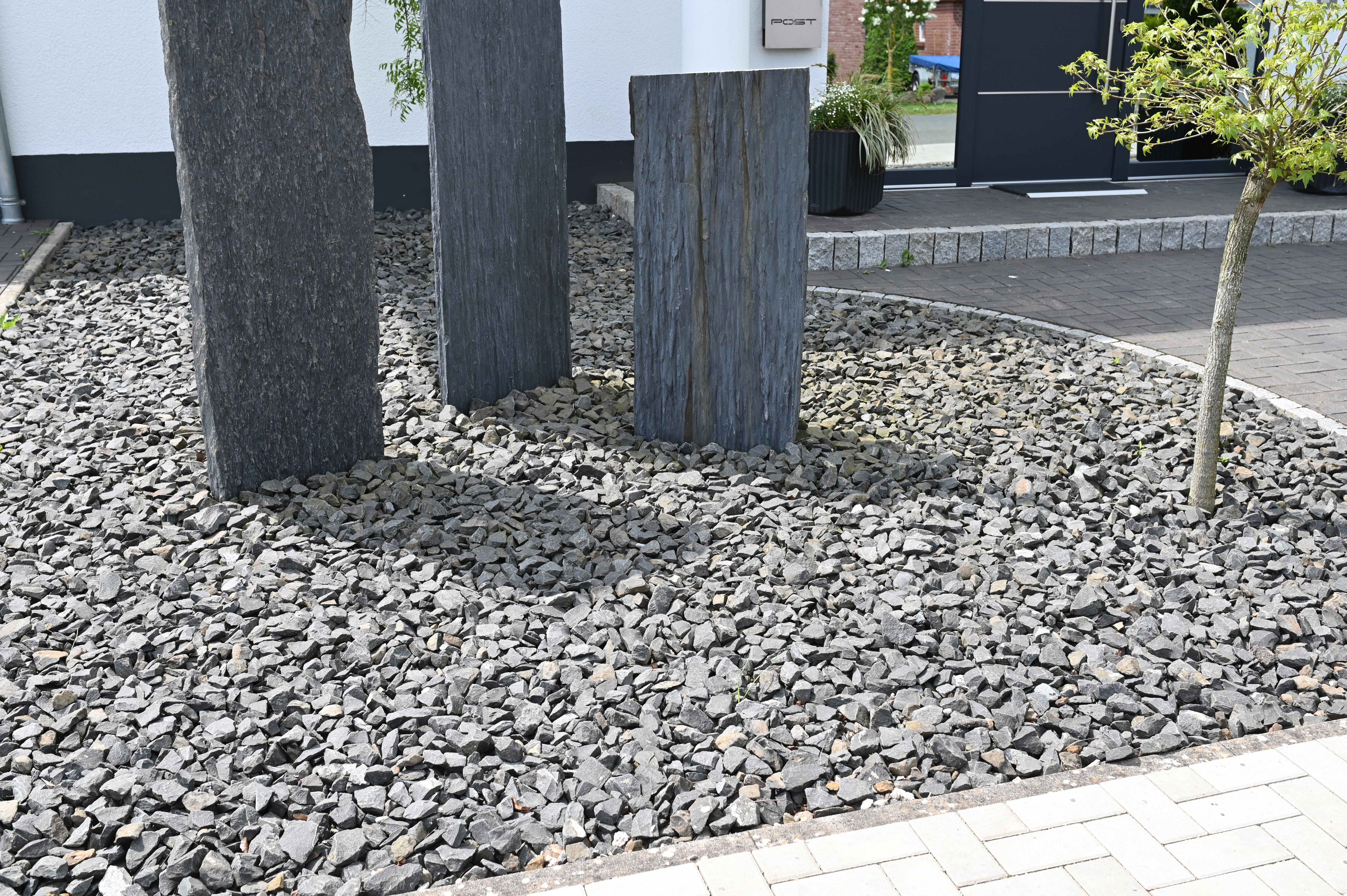 Grey slate chippings for gardens, forty millimeters, with light grey rock texture.
