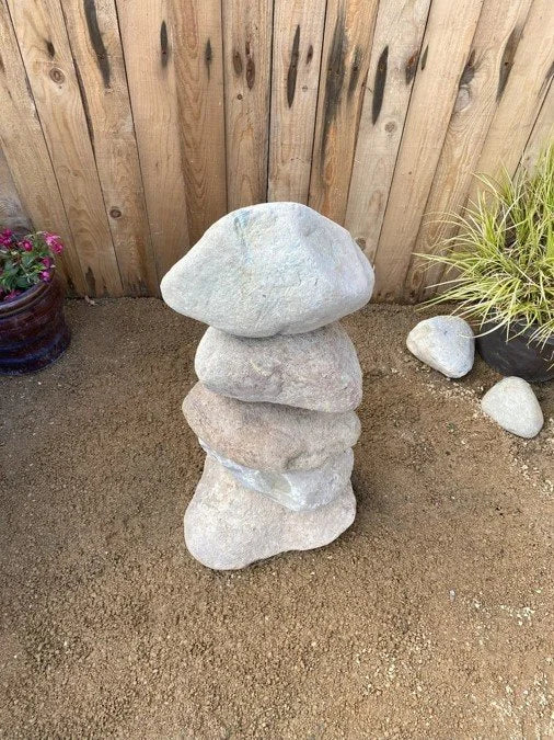 Small stacked stone pebble tower by Artisan Crafted, featuring natural rock textures and outdoor decor.