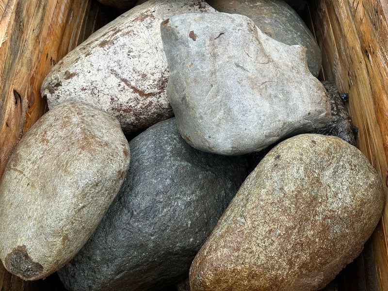 Pile of decorative garden boulders with textured surface.