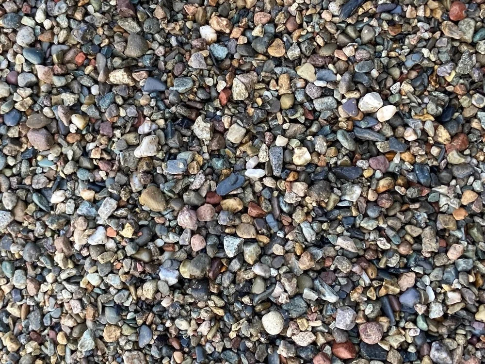 Multi-colored drainage gravel, 20mm in size, forming a dense, textured surface.
