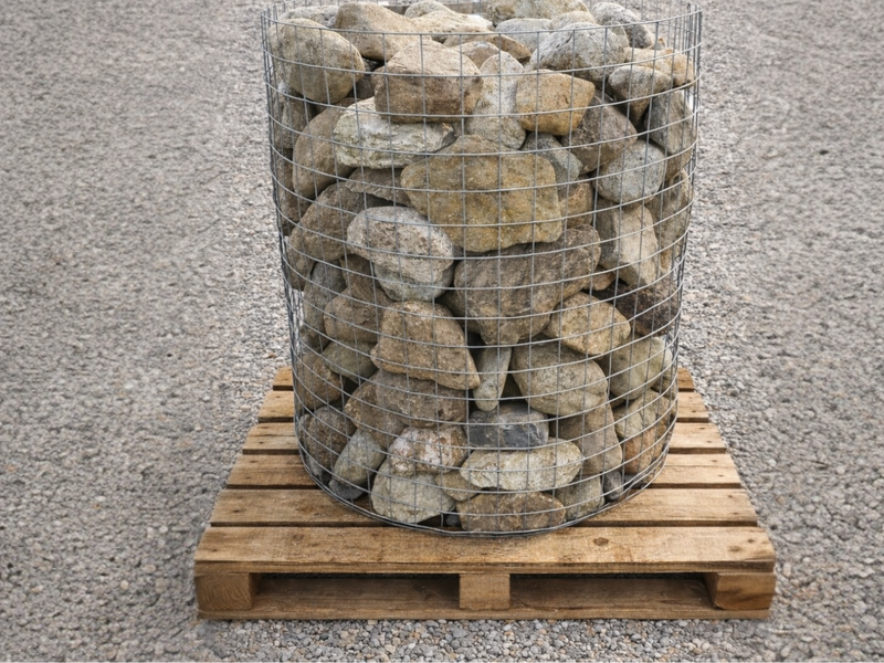 Small decorative garden boulders in a wire cage on a wooden pallet.