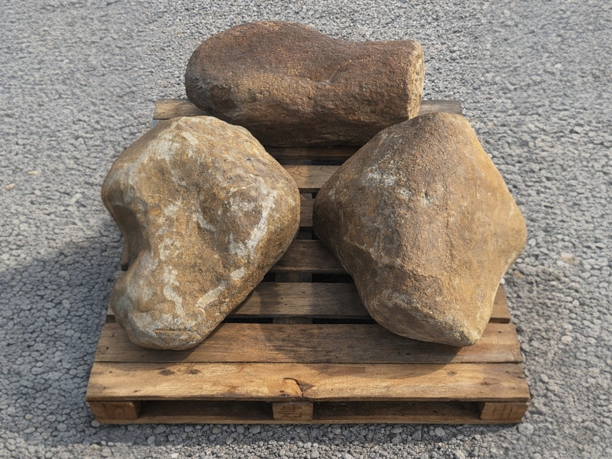 Trio of decorative garden boulders, from 600 to 900 mm, on a wood pallet.
