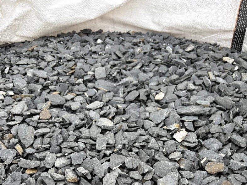 Grey slate chippings for pond edging, 20mm by size, with rough texture in a filled white sack.
