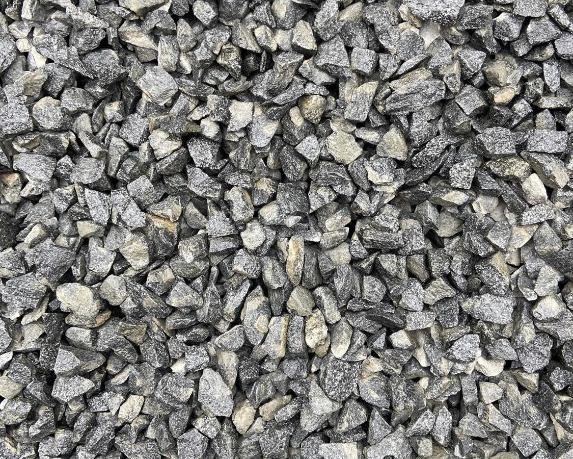 20mm black granite pond chippings with a rough, fragmented texture.
