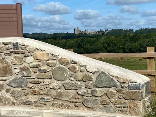 Natural walling stone boulder, with gray and beige colors, displaying a rough texture and irregular shapes.
