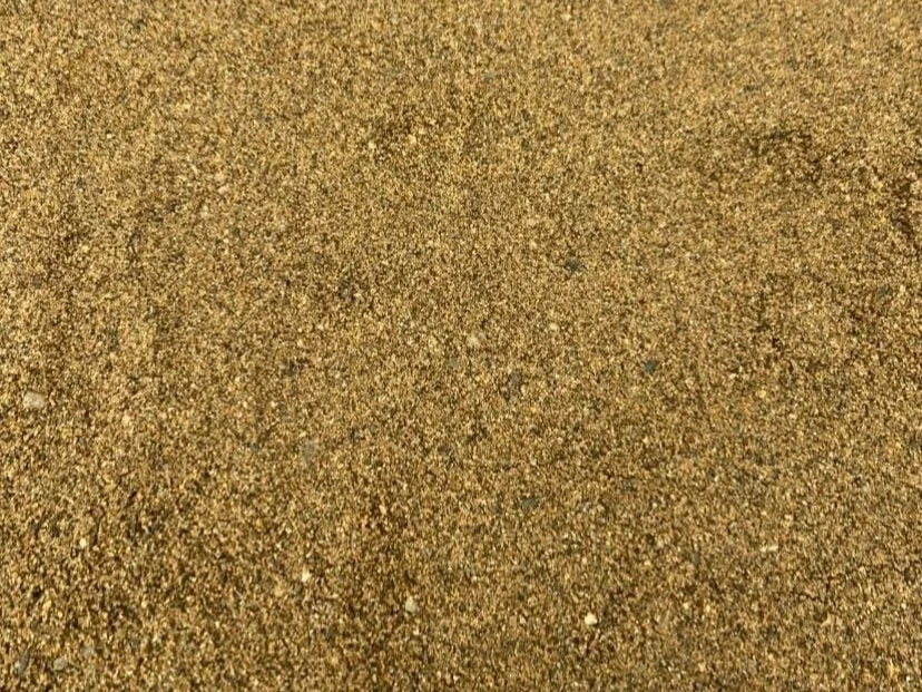 Tan building sand in bulk bag with fine, gritty texture.