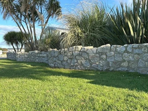 Natural limestone walling stone featuring a gray stone texture with grassy foreground.
