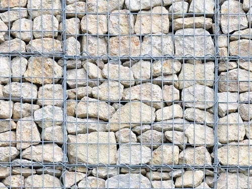 Light limestone gabion stones for gabion baskets with gray wire mesh holding stones in place.
