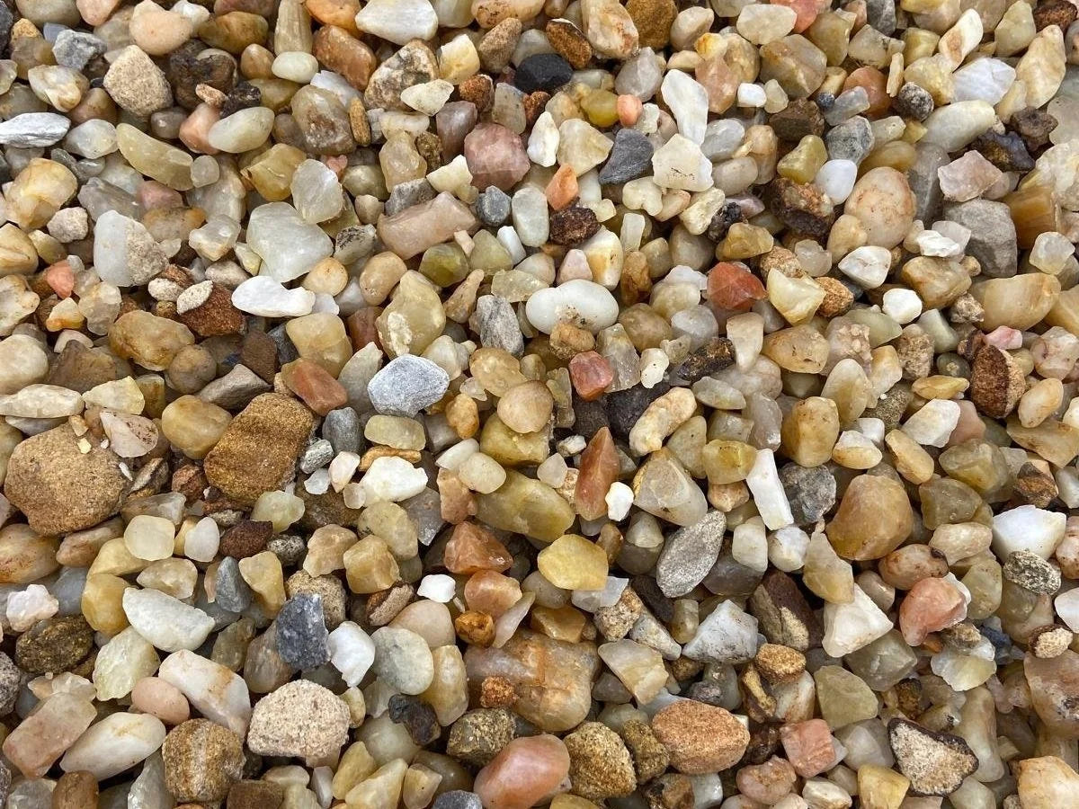Rose quartz pond chippings, 20mm, with a natural texture and assorted earth-toned pebbles.
