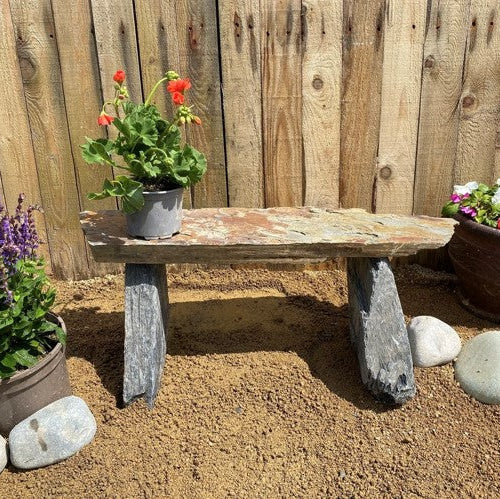 Rustic slate pot stand with natural stone legs.