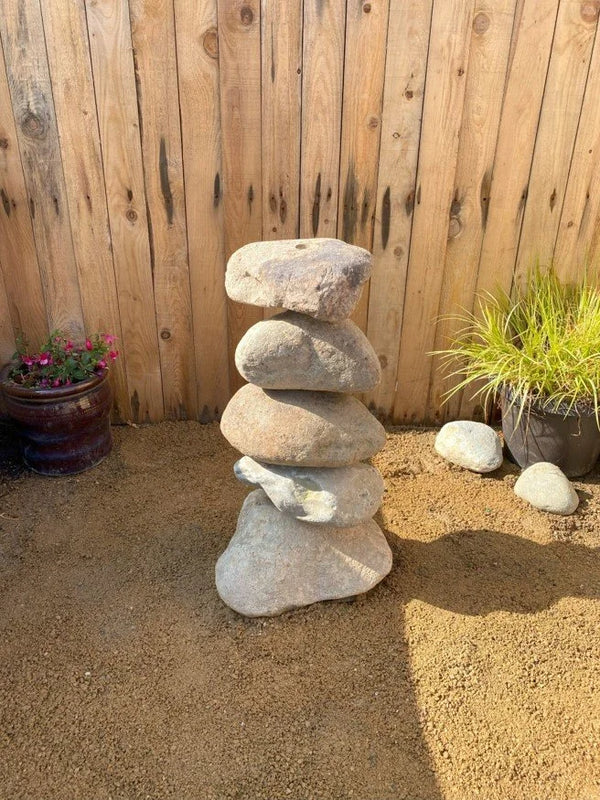 Small natural pebble water feature, sixty centimeters, with stacked stone design.